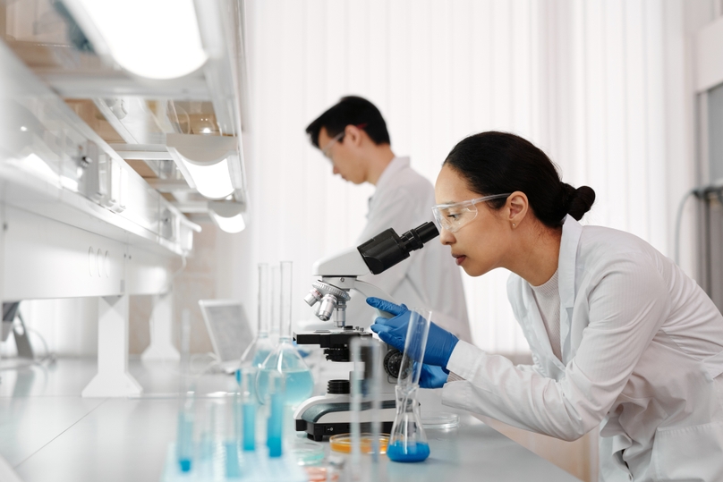 Two lab techs working on a workbench